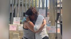La madre abrazada a una amiga durante una manifestación a las afueras de Medicina Legal